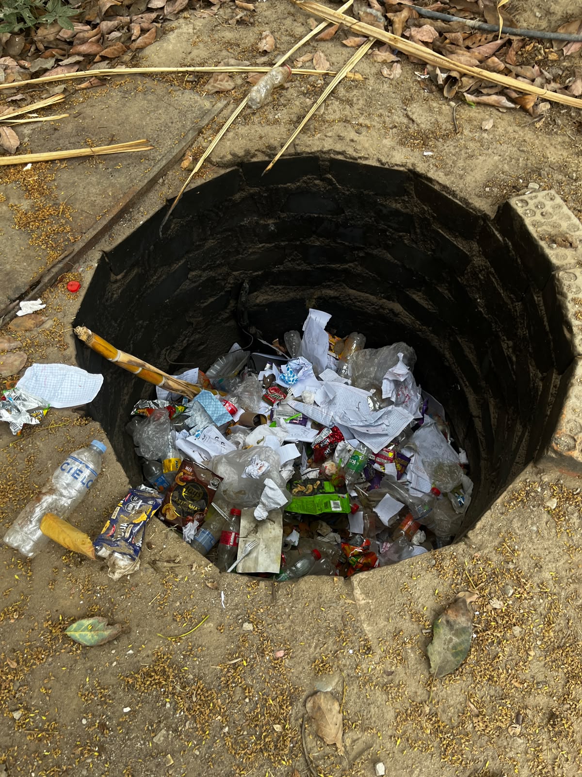 Residuos mezclados acumulados en un pozo del predio escolar